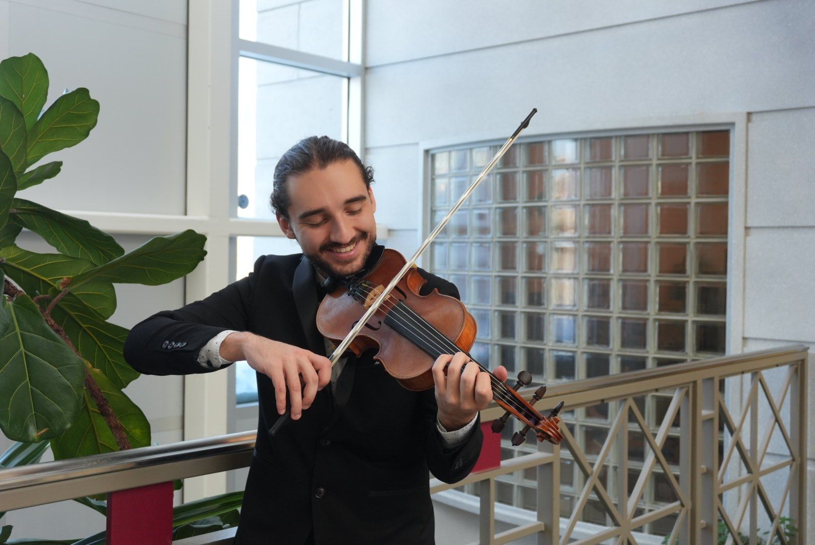 Antoine Fradkin en smoking joue du violon en riant