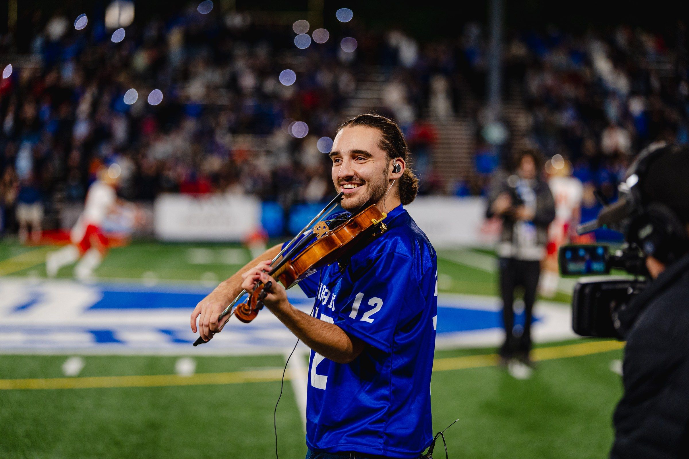 Antoine Fradkin sur le terrain de football avec son violon