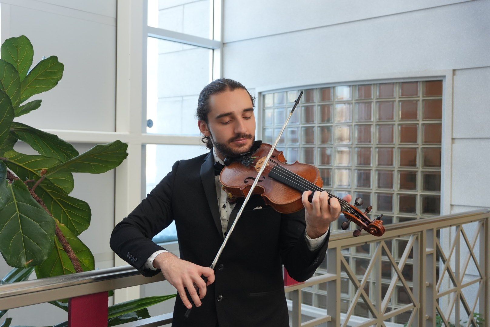 Antoine Fradkin en smoking joue du violon, les yeux fermés