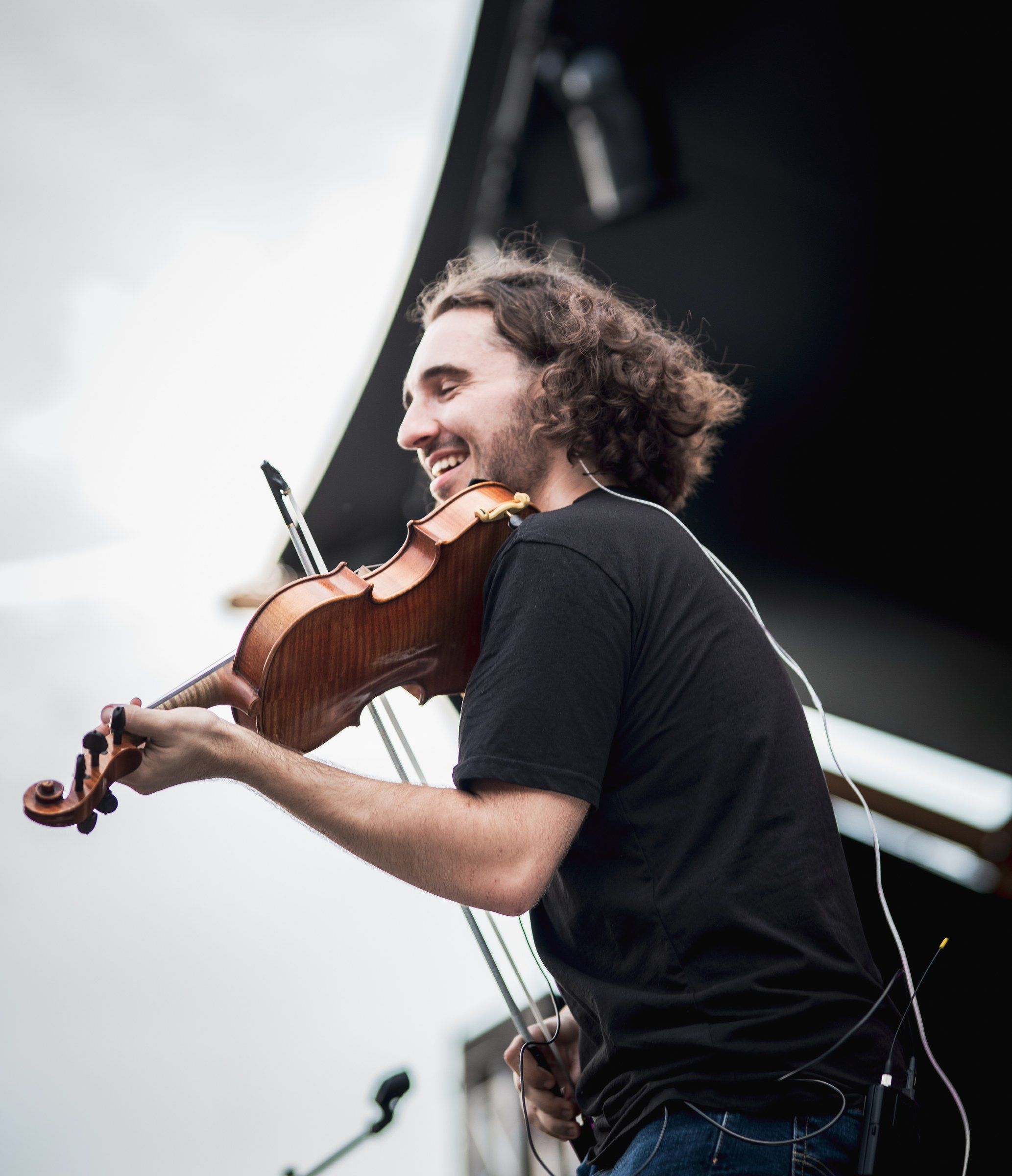 Antoine Fradkin joue du violon sur scène en festival, tout sourire