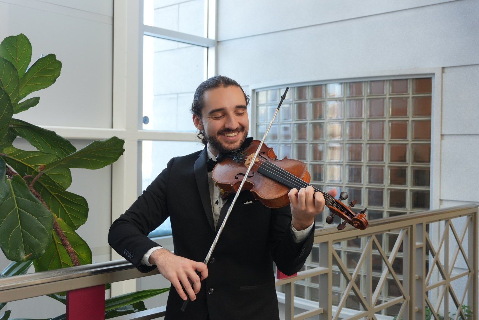 Antoine Fradkin en smoking joue du violon en souriant